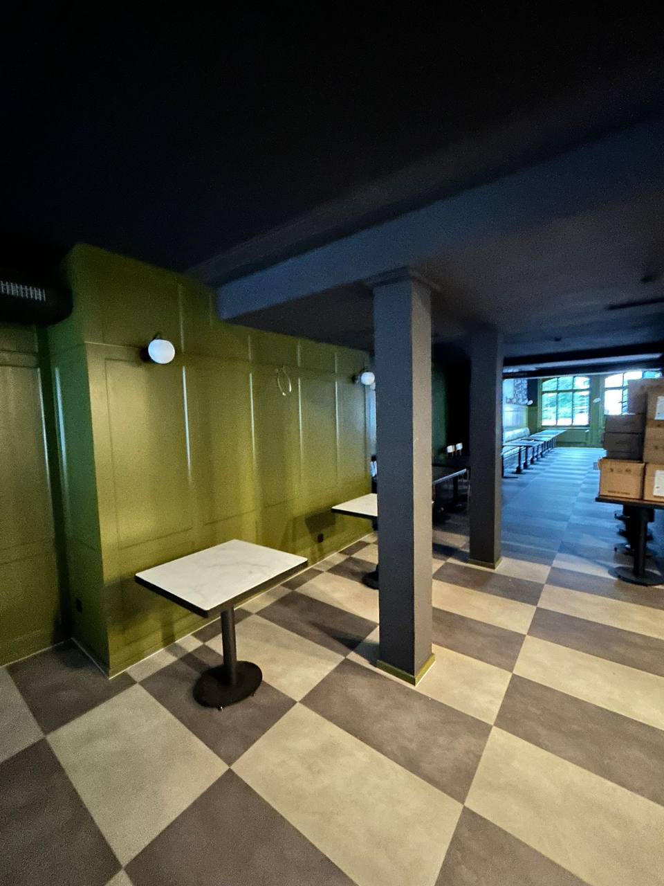 Grüne Wand mit Marmortischen