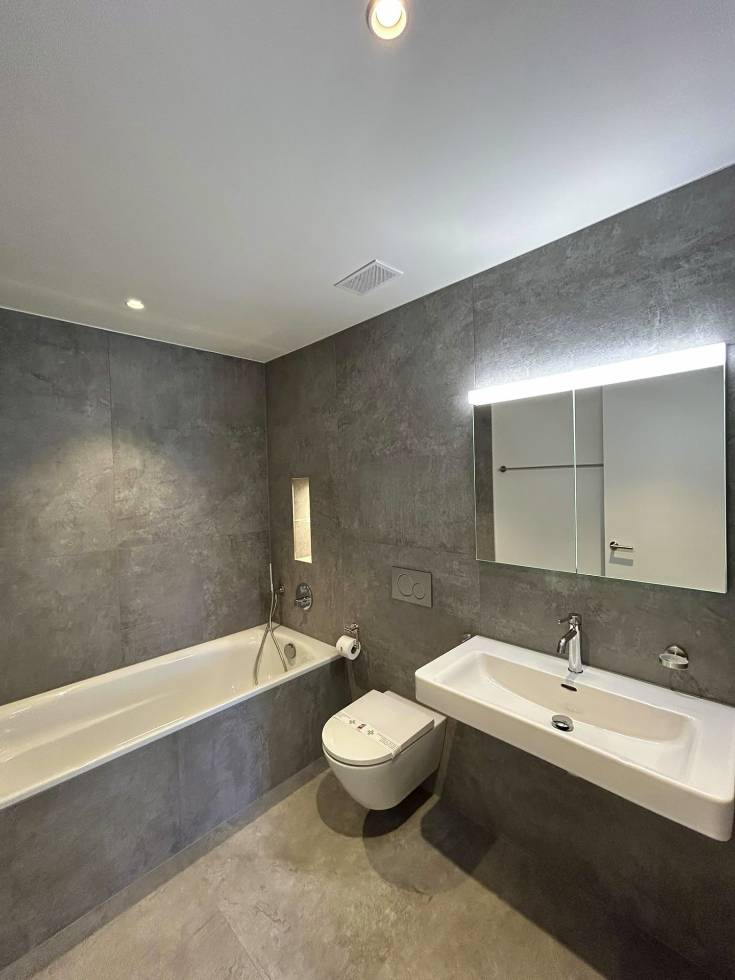 Badezimmer mit Wanne und Spiegelschrank